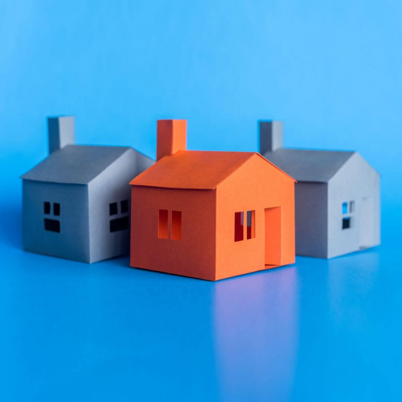 3 blue and red toy houses on bright blue background